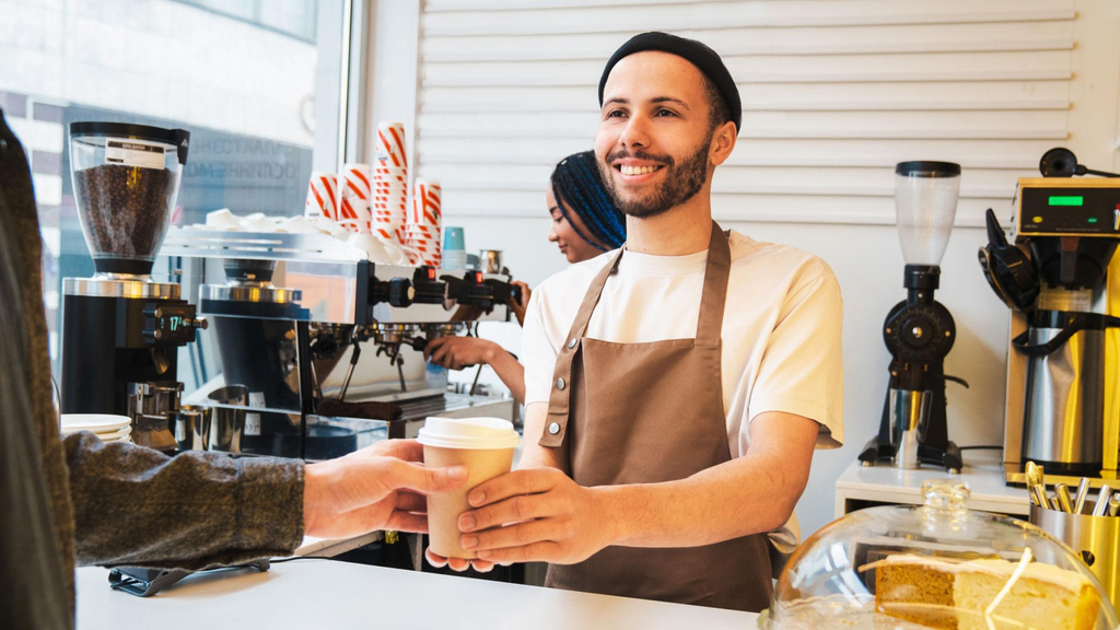 Disposable coffee cups used by baristas during busy takeaway coffee service