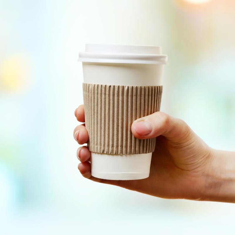 Coffee cup sleeves fitted around takeaway hot coffee cups for comfortable handling